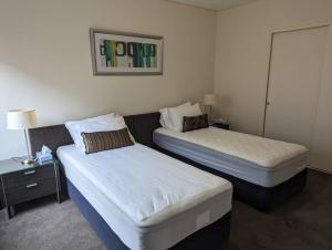 a hotel room with two beds and a night stand at Spacious 2 bedroom apartment @Kingston Foreshore in Kingston 