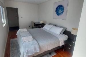 a bedroom with a large bed and a table at Spacious 2 bedroom apartment @Kingston Foreshore in Kingston 