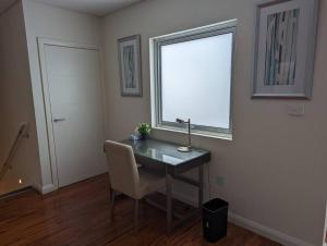 a room with a desk with a chair and a window at Spacious 2 bedroom apartment @Kingston Foreshore in Kingston 