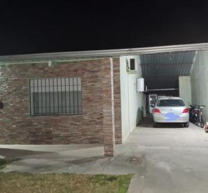 une voiture garée devant un garage la nuit dans l'établissement Apto. en Colonia, a 1 cuadra de la Plaza de Toros, à Colonia del Sacramento
