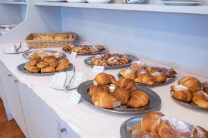 uma mesa com pratos de croissants e outros produtos de pastelaria em Hotel Diamond em Rimini