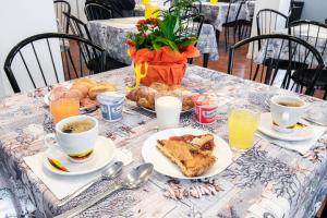uma mesa coberta com pratos de comida e chávenas de café em Hotel Diamond em Rimini