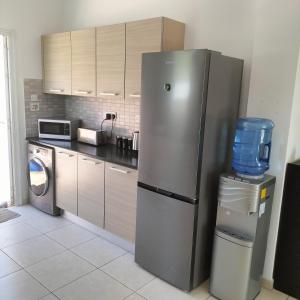 a kitchen with a refrigerator and a washing machine at Luxury Villa Private Pool and Wifi Perfect location for a holiday in Protaras