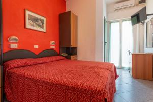 um quarto vermelho com uma cama com uma parede vermelha em Hotel Diamond em Rimini