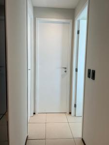 a white door in a hallway with a mirror at Terraços do Atlântico - Apto Beira Mar Fortaleza in Fortaleza