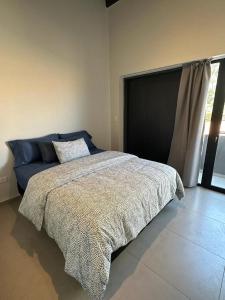 1 dormitorio con 1 cama con manta y ventana en Bosques de Mayo en Maipú