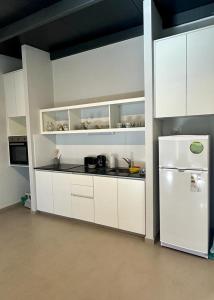 a kitchen with white cabinets and a white refrigerator at Bosques de Mayo in Maipú