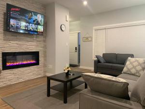 a living room with a couch and a tv at Luxurious 3 BR Villa with free parking - King Bed in Regina