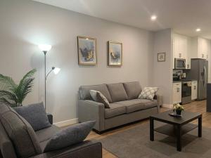 uma sala de estar com um sofá e uma mesa em Luxurious 3 BR Villa with free parking - King Bed em Regina