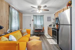 a living room with a yellow couch and a refrigerator at Orange Blossom Place-Walk to shops bars & food in Tampa