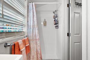 a bathroom with an orange shower curtain next to a sink at Orange Blossom Place-Walk to shops bars & food in Tampa