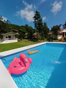 una carroza rosa en una piscina en Baan Suan Rojjana, en Muak Lek