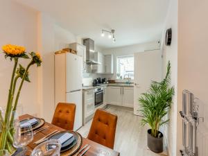 een keuken met een tafel en stoelen en een witte koelkast bij Phoenix House in Kingsbridge