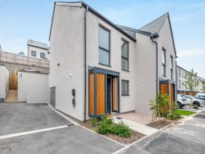 een lege parkeerplaats voor een wit huis bij Phoenix House in Kingsbridge