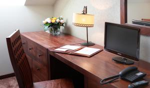 a desk with a computer monitor and a vase of flowers at Chochołowy Dwór in Jerzmanowice +37 photos