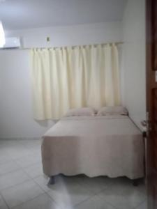 een slaapkamer met een bed en een raam met gordijnen bij Pousada Balsas in Balsas