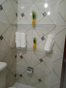 estante de cristal en el baño con toallas en Pousada Balsas, en Balsas