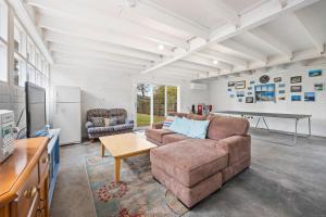 - un salon avec un canapé et une table dans l'établissement Overloaded with Beachside Charm, à Inverloch