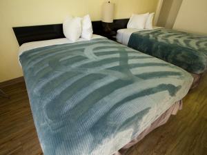 two beds sitting next to each other in a room at Creston Valley Motel in Creston