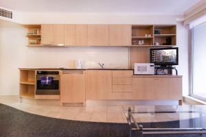 een keuken met houten kasten en een magnetron bij PI702 - Ideally Located Sydney CBD in Sydney