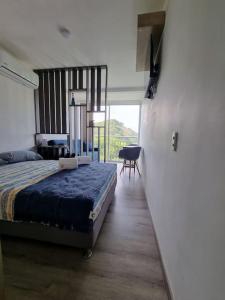 a bedroom with a bed and a table and a chair at Apartamento Nuevo en Santa Marta Rodadero in Gaira +8 photos