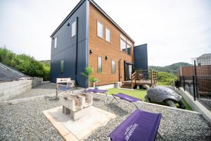 una casa con un patio trasero con cojines morados en Awaji Seaview Resort in Nojima, en Kusumoto