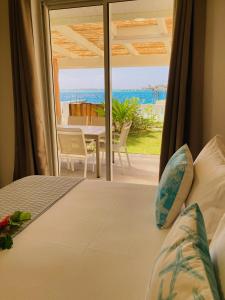 a bedroom with a bed and a view of the ocean at Matira Beach House in Bora Bora