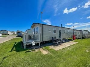a mobile home sitting on top of a field of grass at Superb 8 Berth Caravan For Hire At A Great Holiday Park In Norfolk Ref 50007a in Great Yarmouth