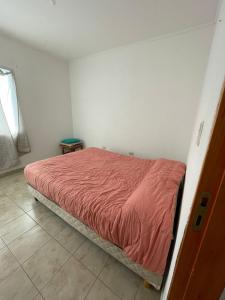 una camera con un letto con una coperta rossa di DUPLEX BV a Bell Ville