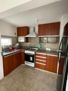 a kitchen with wooden cabinets and a stove top oven at DUPLEX BV in Bell Ville