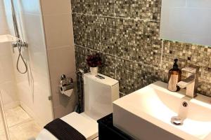 y baño con aseo, lavabo y ducha. en Home Abroad 2 @ Jazz Suites Vivacity, en Kuching