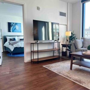 a living room with a television and a bed at Lux 2BR 2BR BackBay Boston Common T-station in Boston