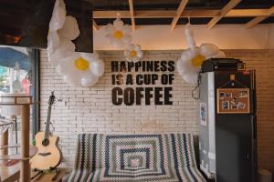 a brick wall with a signappiness is a cup of coffee at Cazz Hostel in Bangkok