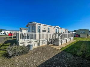a house with a white railing and a porch at Lovely Caravan With Decking At Manor Park, Near Hunstanton Beach Ref 23034c in Hunstanton