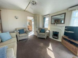 a living room with a fireplace and a television at Lovely Caravan With Decking At Manor Park, Near Hunstanton Beach Ref 23034c in Hunstanton