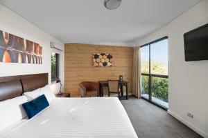 a bedroom with a bed and a table and a television at Balgownie Estate Yarra Valley in Yarra Glen