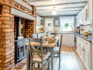 a kitchen with a table and chairs and a brick wall at Mrs Crackers Cottage in Lund