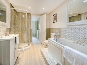 a white bathroom with a tub and a shower at Mrs Crackers Cottage in Lund