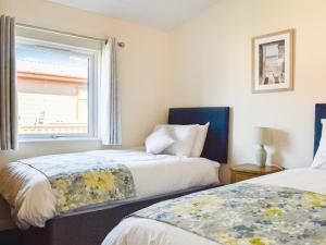 a bedroom with two beds and a window at Lodge 38 in Stonham Aspall