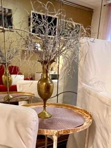 una mesa con un jarrón de oro encima en Art Deco Mosilor, en Bucarest