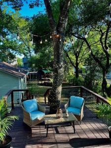 a deck with two chairs and a table and a tree at Argo Häuschen in Alamo Heights in San Antonio