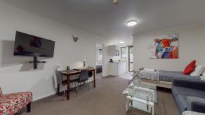 a living room with a couch and a dining room at Matariki Motor Lodge in Te Awamutu