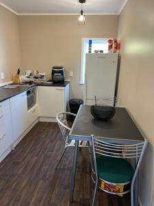 uma cozinha com uma mesa e cadeiras e um frigorífico em FISHERMANS’DELIGHT em Whangaroa
