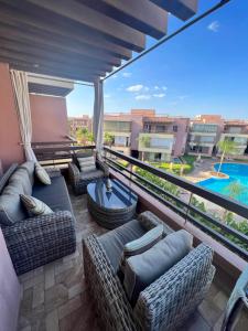 d'un balcon avec des canapés et une vue sur la piscine. dans l'établissement Appart avec Piscine, Riad Garden, à Marrakech