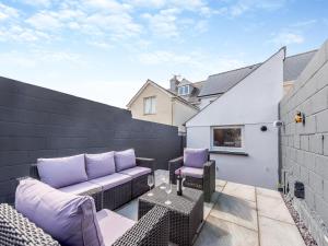a patio with a couch and a table on a balcony at The Haven in Milford Haven