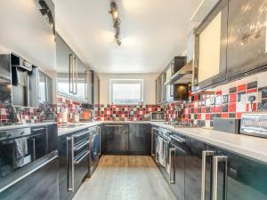 una grande cucina con elettrodomestici in acciaio inossidabile e una finestra di The Haven a Milford Haven