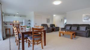 a kitchen and living room with a table and a couch at unit 9 11 Kyeamba Street, Merimbula in Merimbula +8 photos