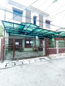 ein Tor vor einem Gebäude mit einem Zaun in der Unterkunft Kost Griya Asri by ecommerceloka in Jakarta