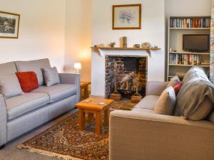 a living room with two couches and a fireplace at 1 Brandiston Barn Cottage in Cawston