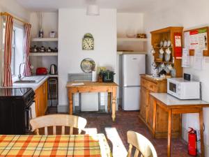 a kitchen with a table and a white refrigerator at 1 Brandiston Barn Cottage in Cawston